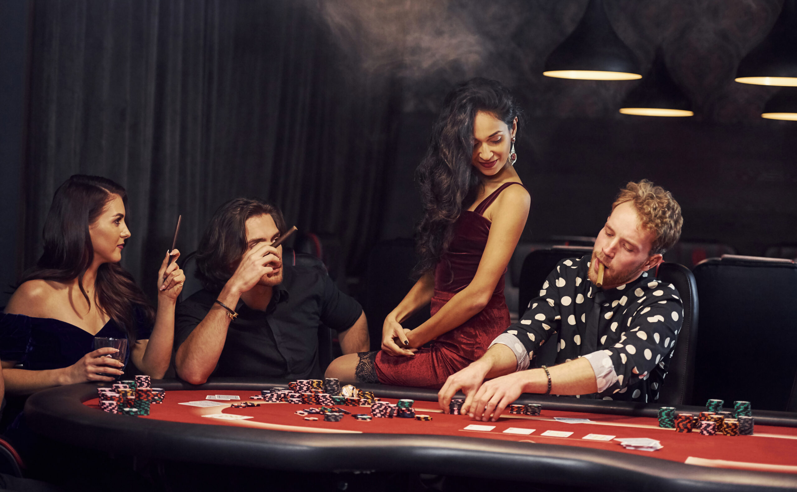 Group of elegant young people that playing poker in casino together.
